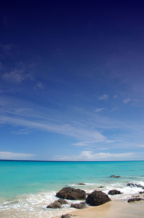 Sunny blue sky beach and rocks photo