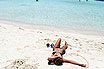 Girl Soaking Up The Sun On The White Sand Beach In Tenerife